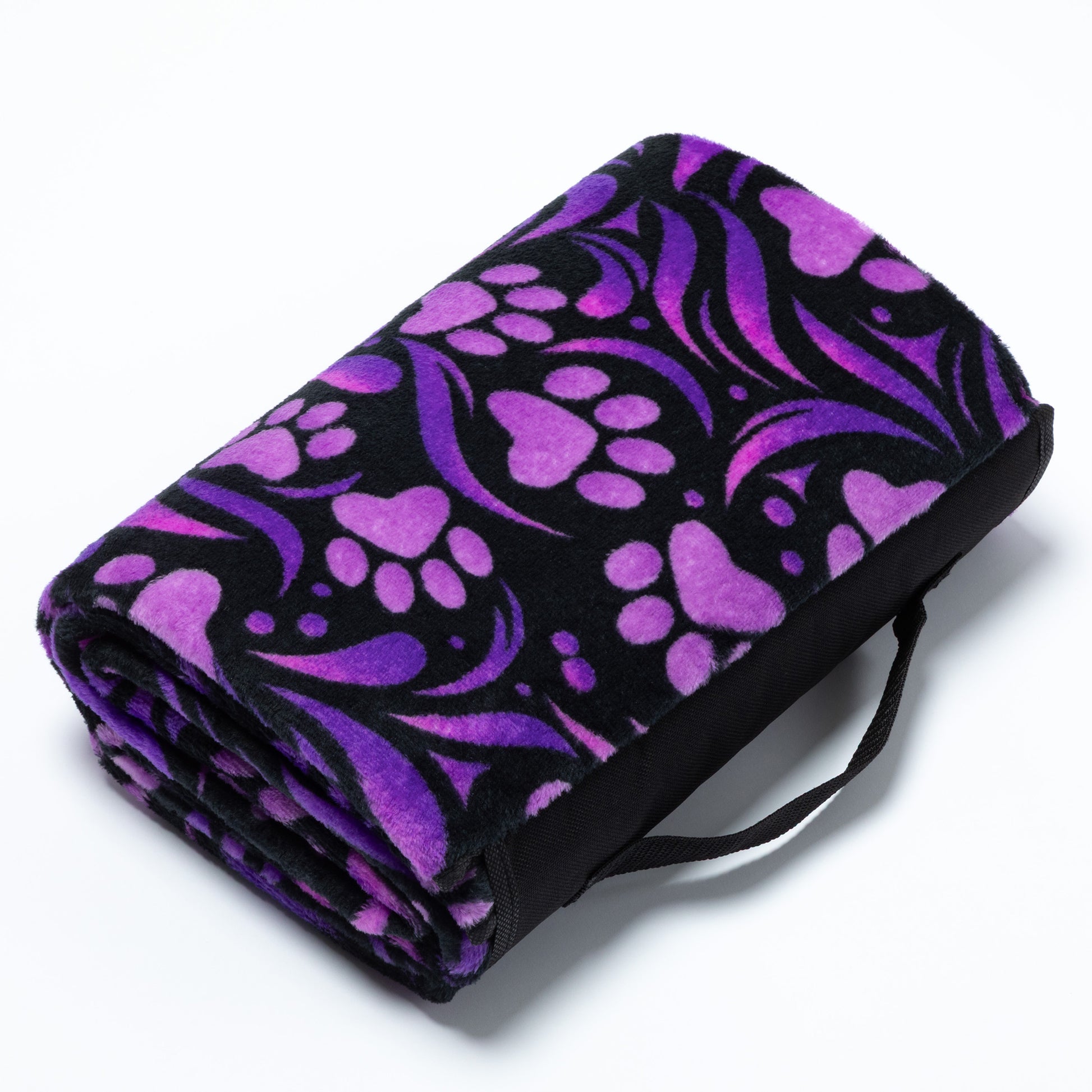 Folded purple and black patterned blanket with a handle on a white background