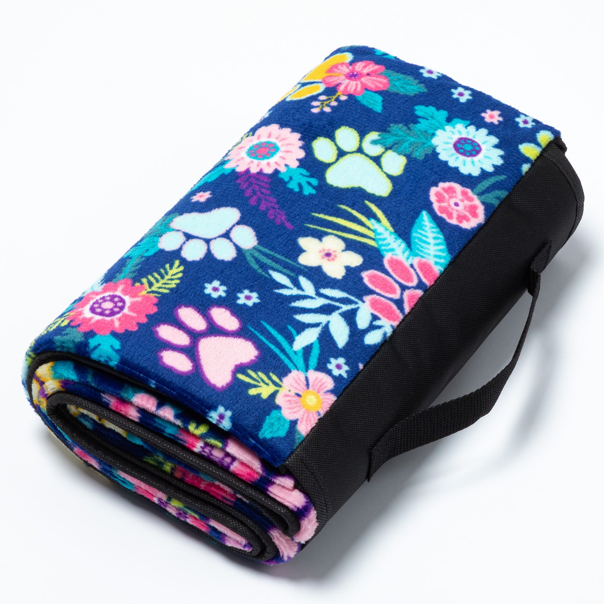 Floral and paw print patterned blanket with a black strap on a white background