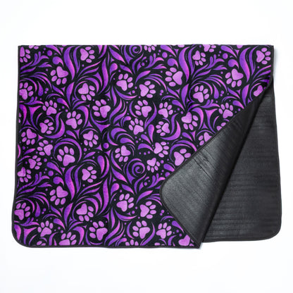 Purple paw print patterned blanket with black backing on a white background.