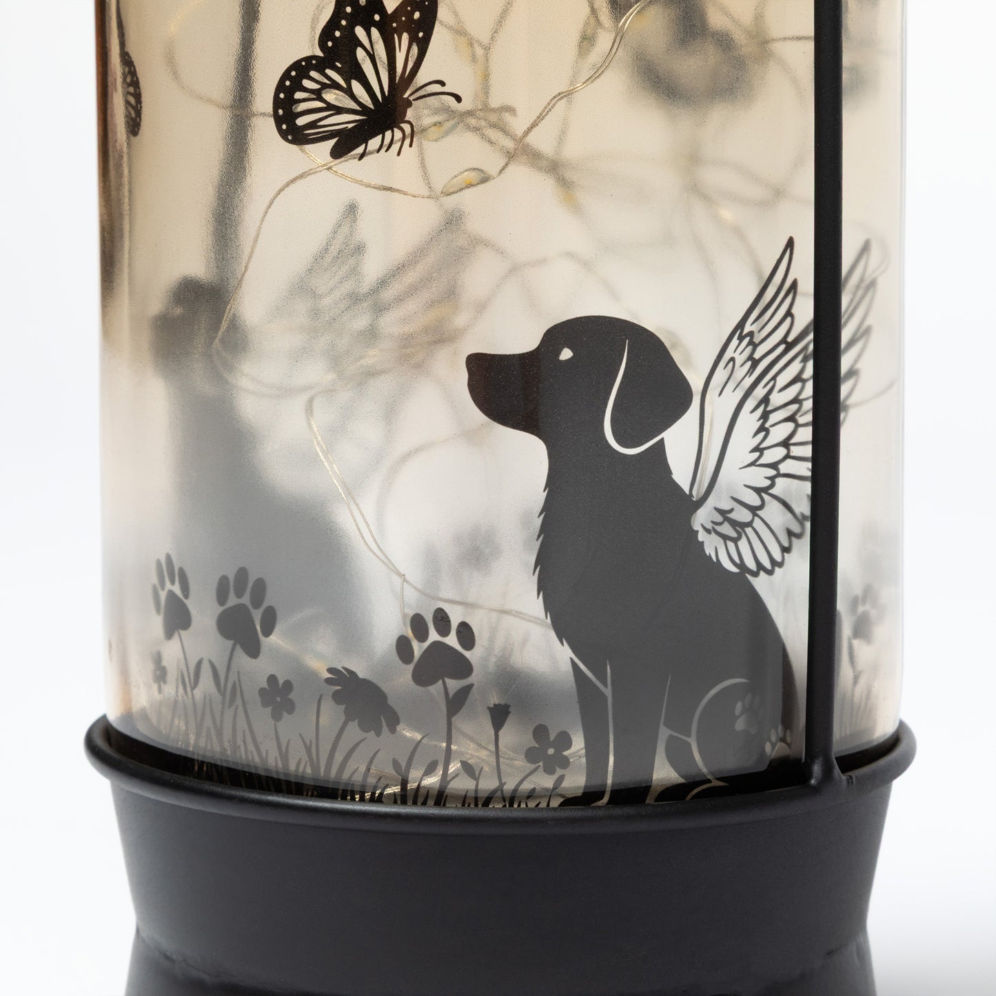 Decorative lantern with a silhouette of a dog with wings, butterflies, and paw prints on a light background.