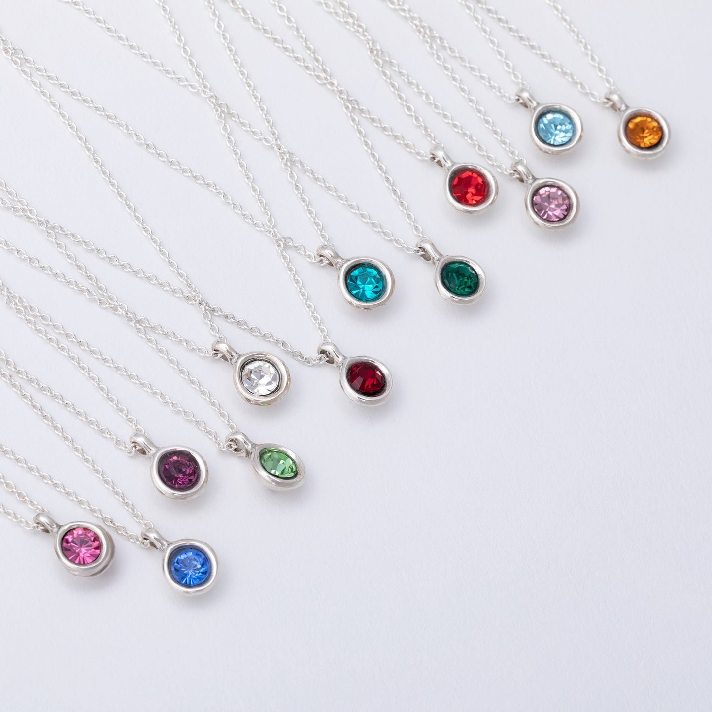 Silver necklaces with colorful gemstones on a white background