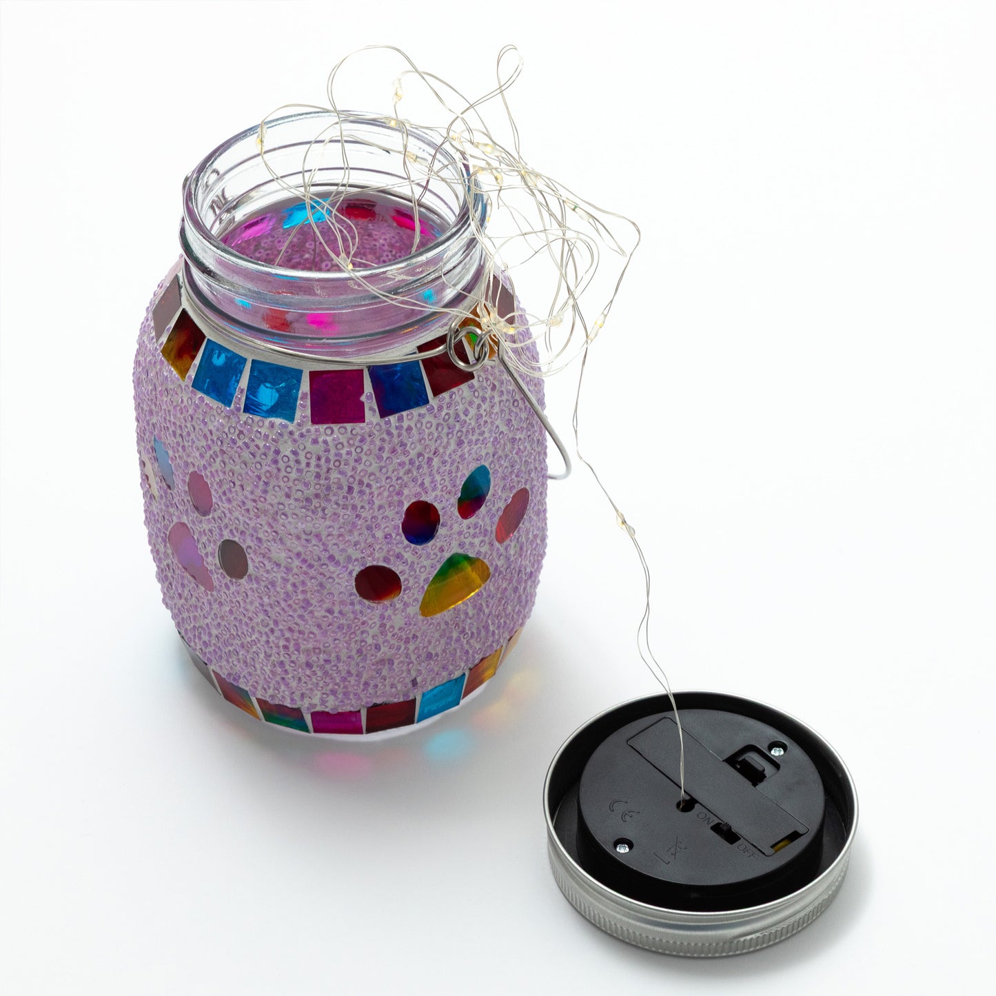 Decorative jar lantern with colorful mosaic design and string lights on a white background