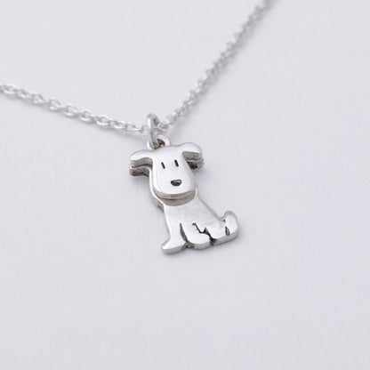 Silver dog-shaped pendant on a chain against a light gray background
