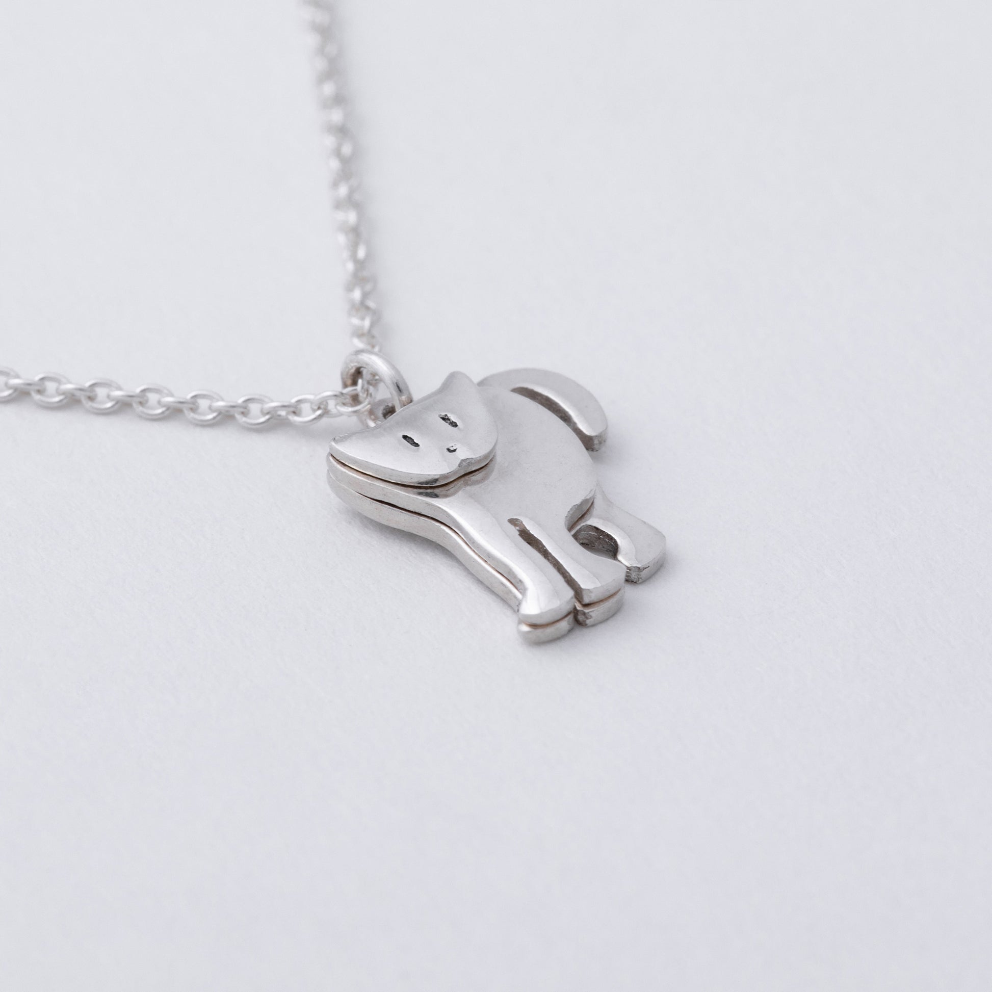 Silver horse-shaped pendant on a chain against a light gray background