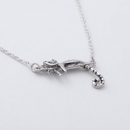 Silver necklace with a unique pendant on a light gray background
