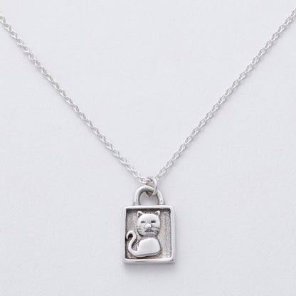 Silver necklace with a cat pendant on a light gray background