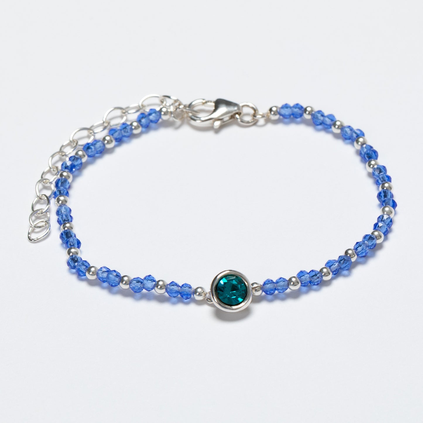 Blue beaded bracelet with a silver clasp on a white background