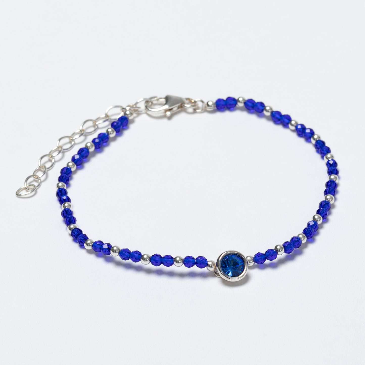 Blue beaded bracelet with a silver clasp on a white background
