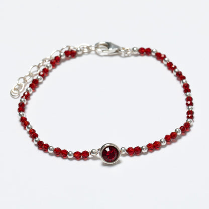 Bracelet with red beads and a silver clasp on a white background