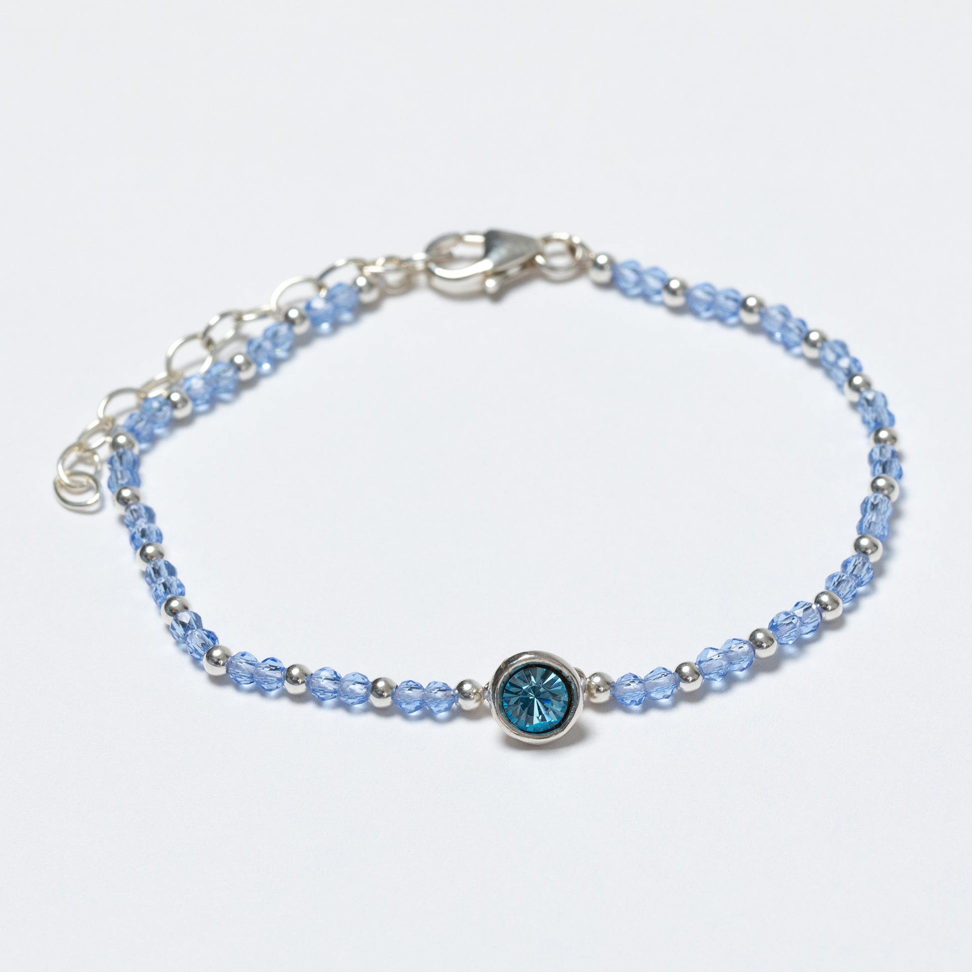 Bracelet with blue gemstone on a light gray background