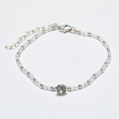 Silver bracelet with a clear gemstone on a light gray background