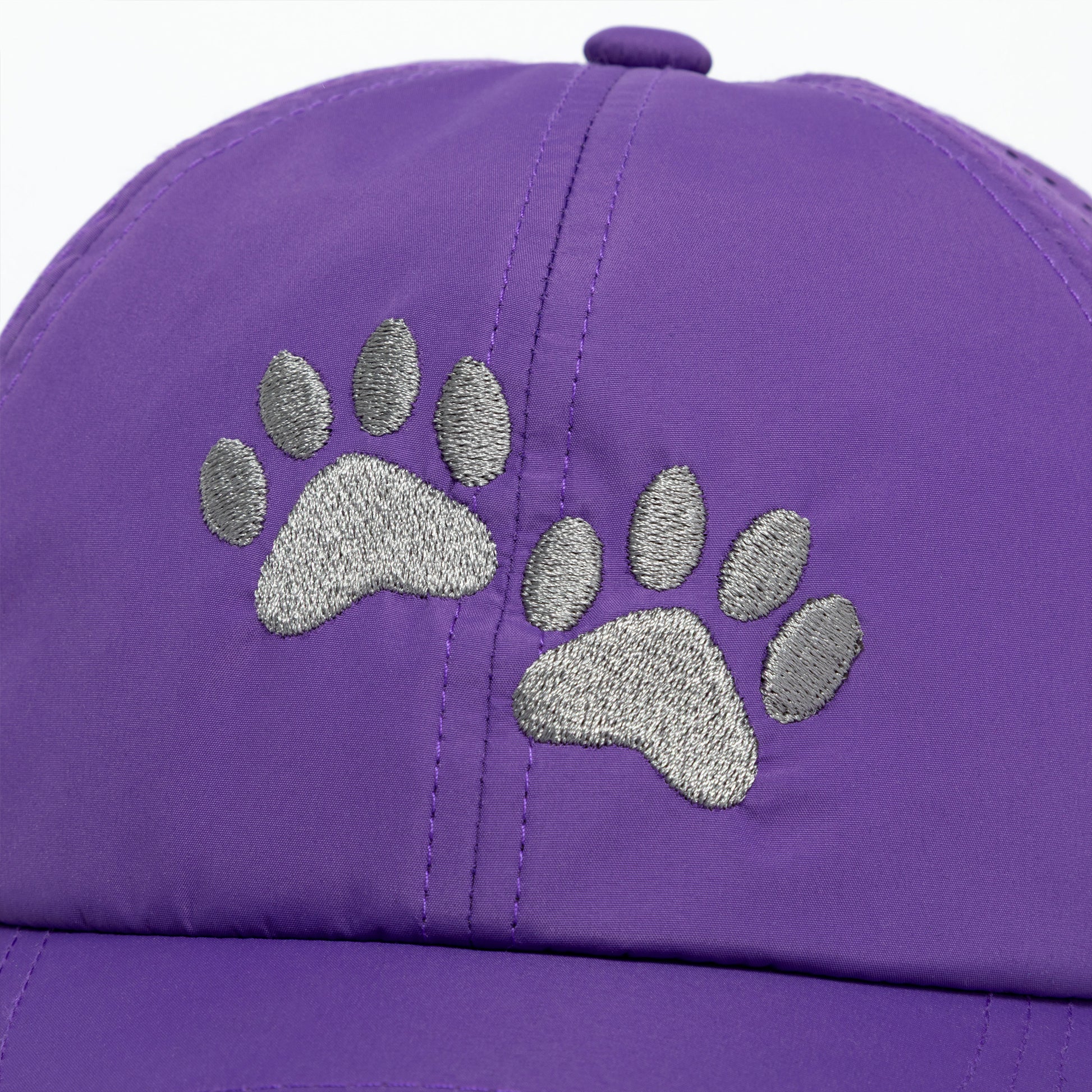 Purple cap with silver paw print design on a white background