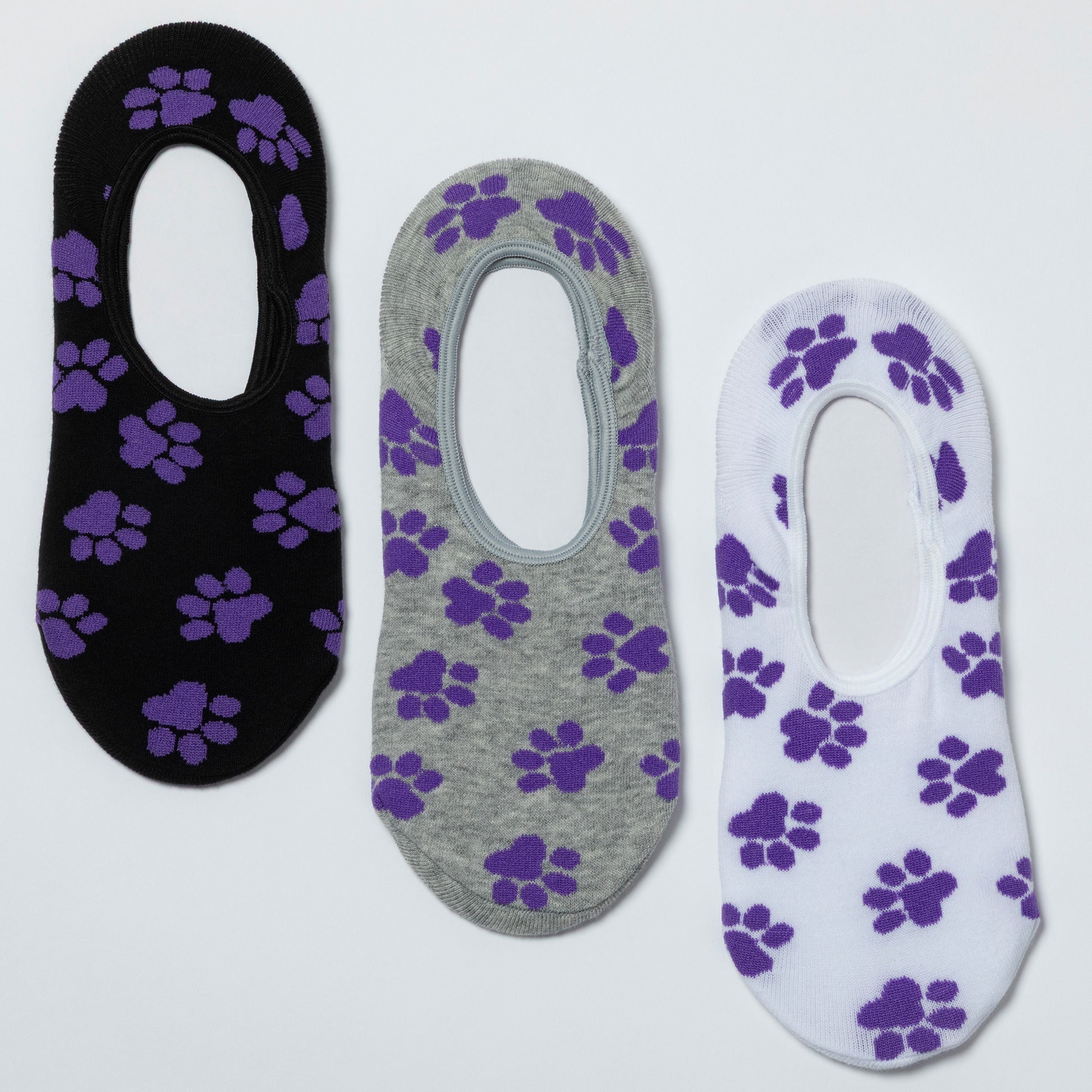 Three pairs of no-show socks with purple paw prints on a white background