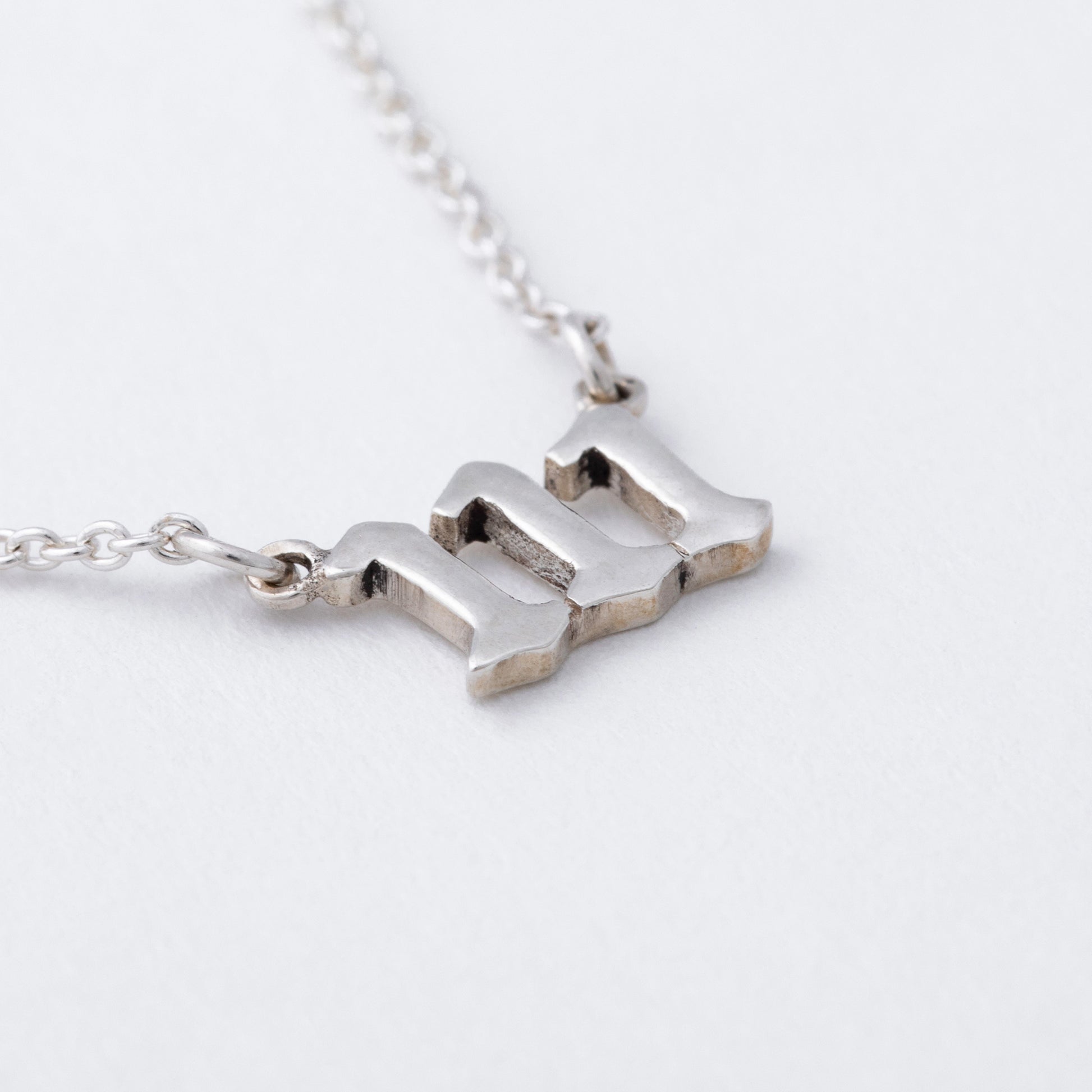 Silver necklace with a unique pendant on a light gray background