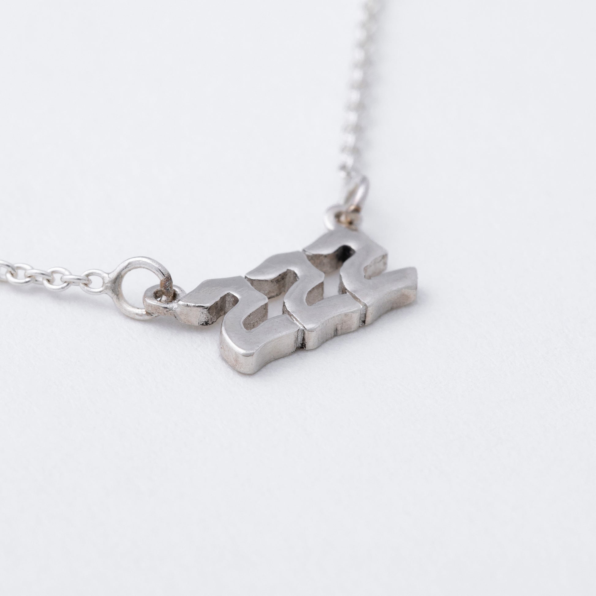 Silver necklace with a unique pendant on a white background