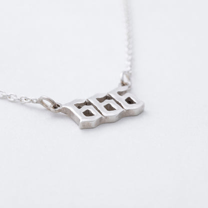 Silver necklace with a unique pendant on a white background
