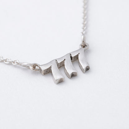 Silver necklace with a unique pendant on a white background