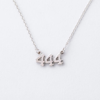 Silver necklace with '444' pendant on a white background