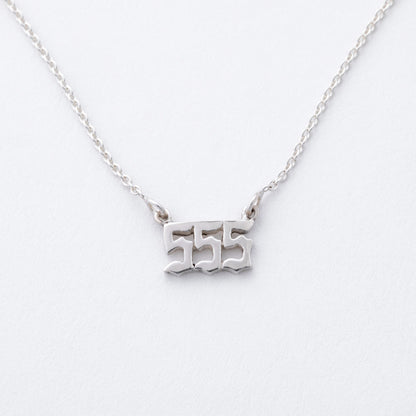 Silver necklace with '555' pendant on a white background