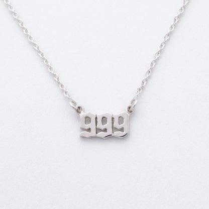 Silver necklace with '999' pendant on a white background