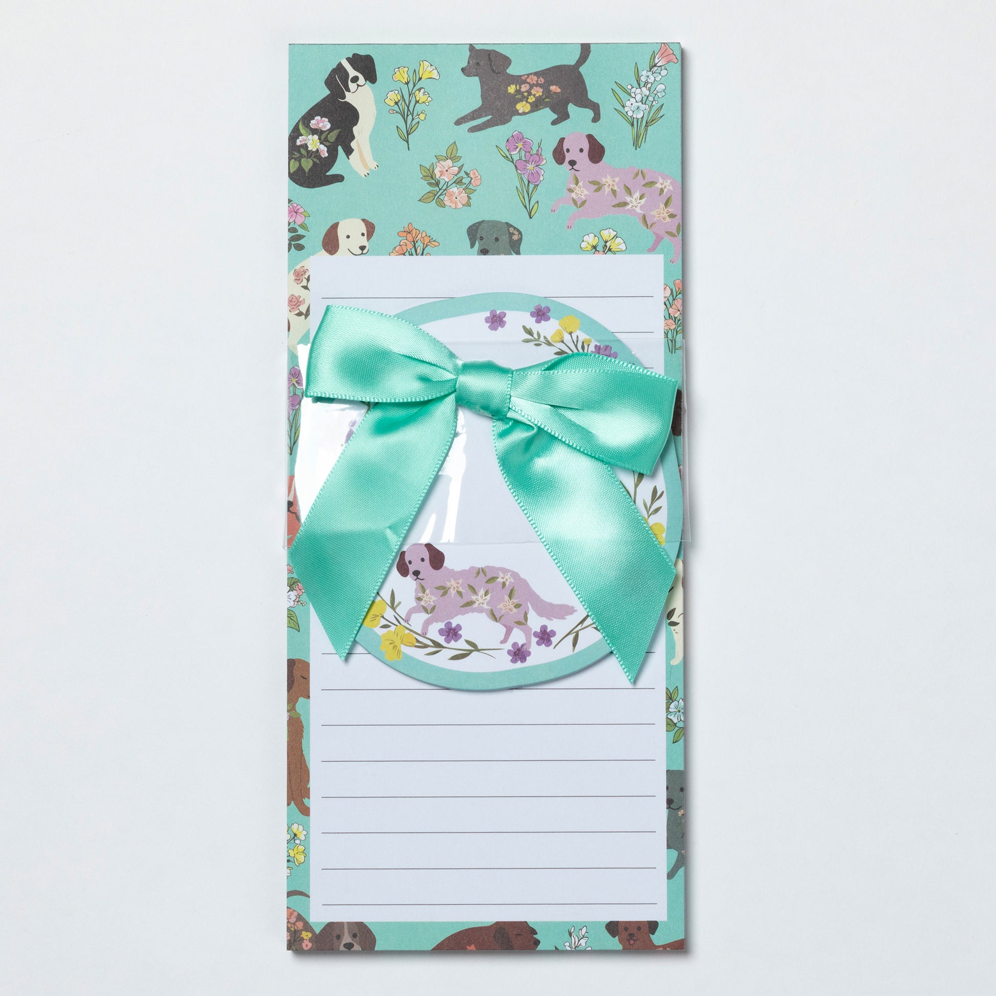 Notepad with dog illustrations and a teal ribbon on a light gray background
