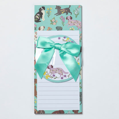 Notepad with dog illustrations and a teal ribbon on a light gray background
