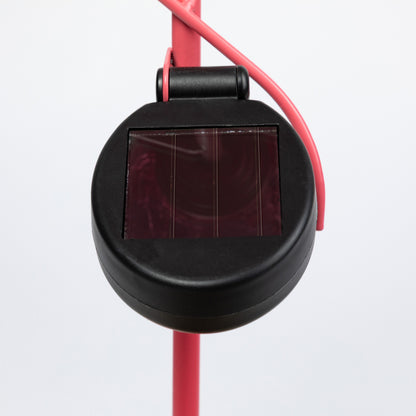 Black solar panel on a pink garden stake on a white background