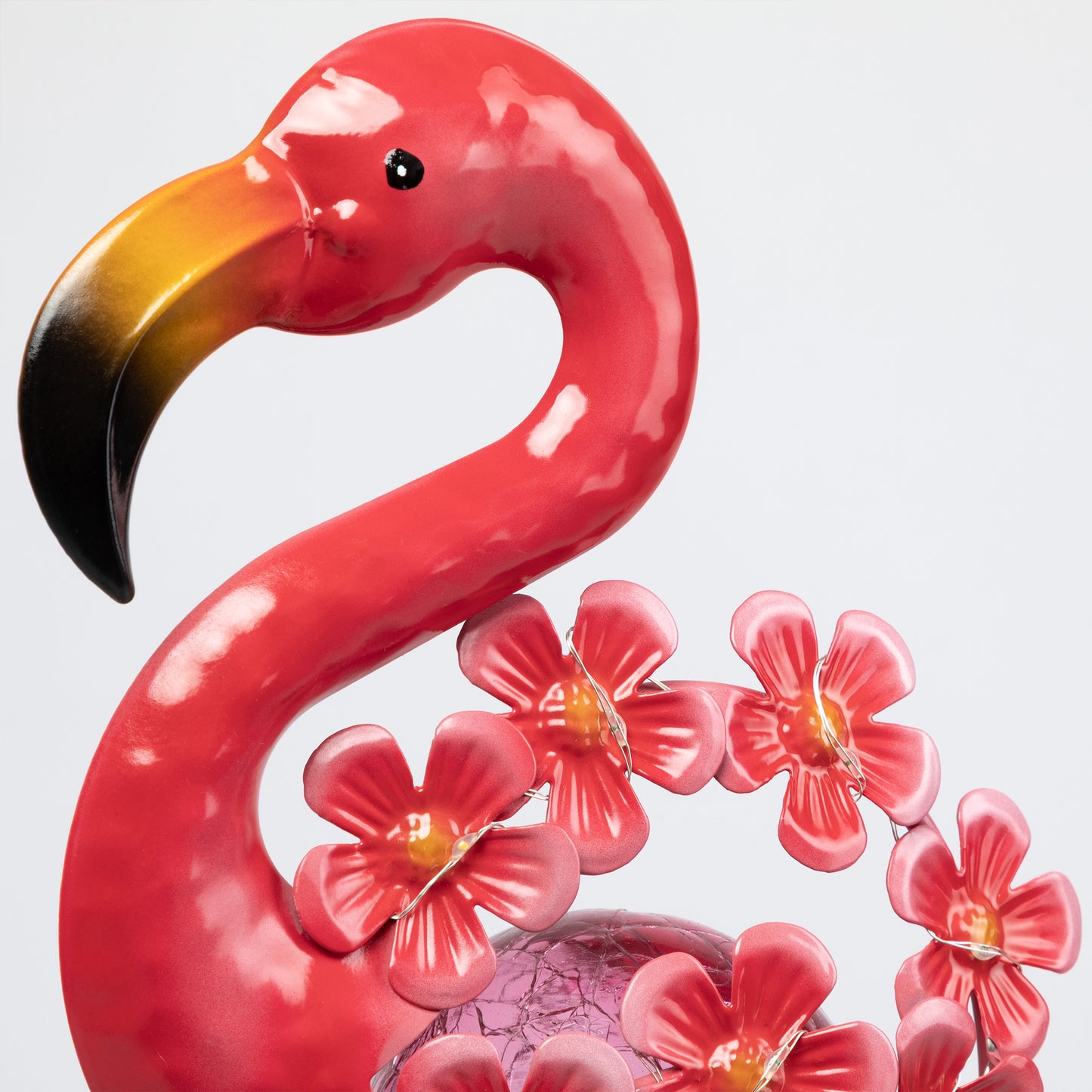 Pink flamingo metal garden stake with flowers on a white background