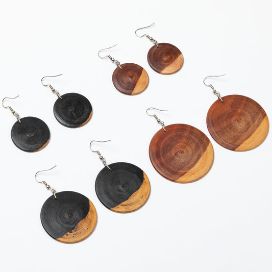 Wooden earrings with black and brown circular designs on a white background