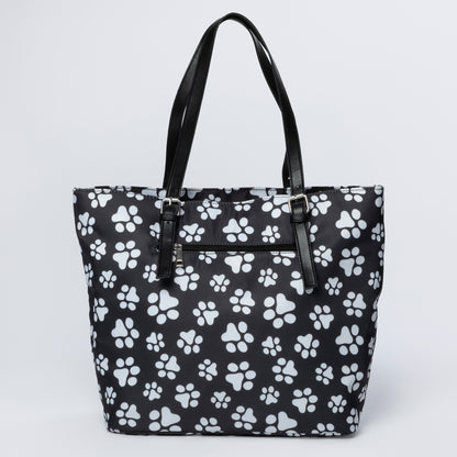 Black tote bag with white paw print pattern on a light gray background