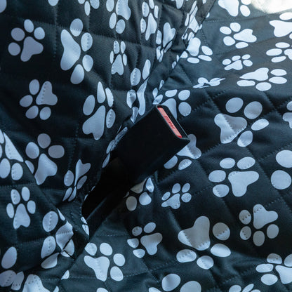Black fabric with white paw prints and a visible buckle.