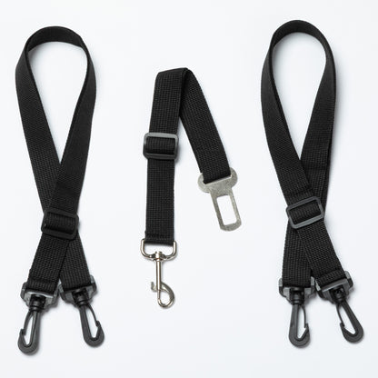 Three black seat belt straps with metal hooks on a white background