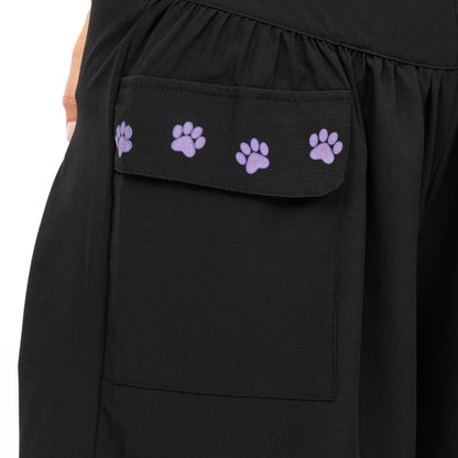 Close up of black shorts with cargo pocket featuring small purple paws on the foldover pocket