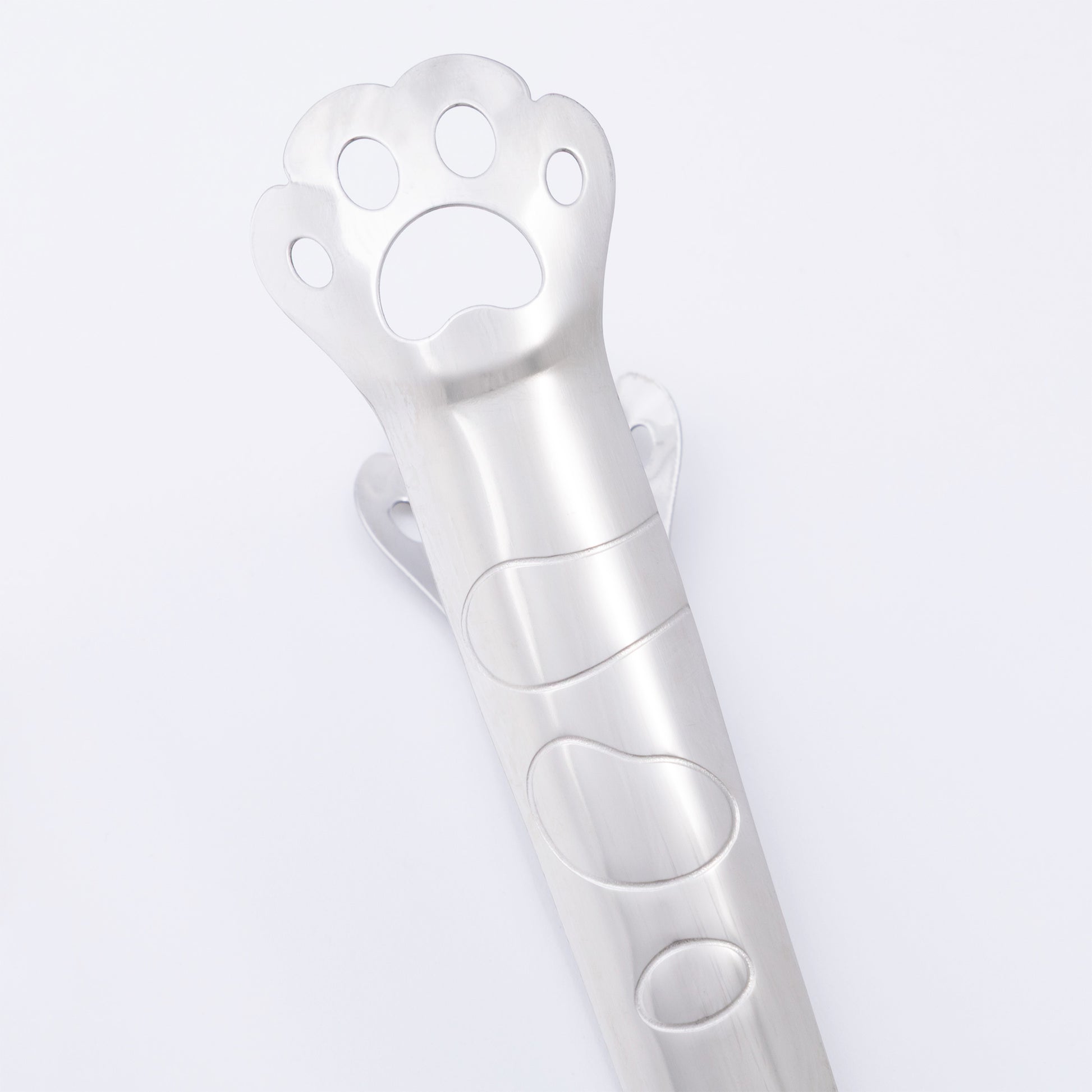 Metallic paw-shaped tongs on a light gray background
