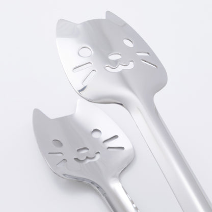 Two cat-shaped utensils on a light gray background