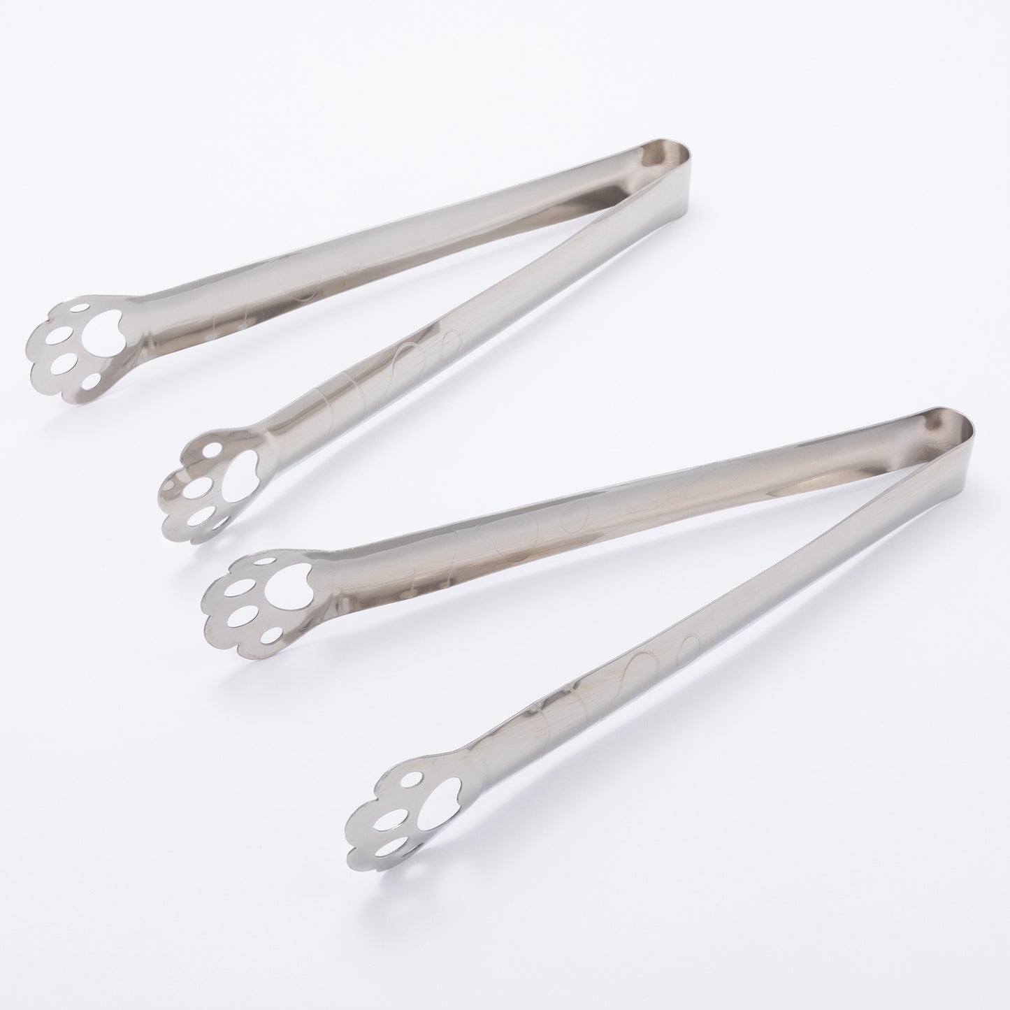Two pairs of silver tongs on a white background