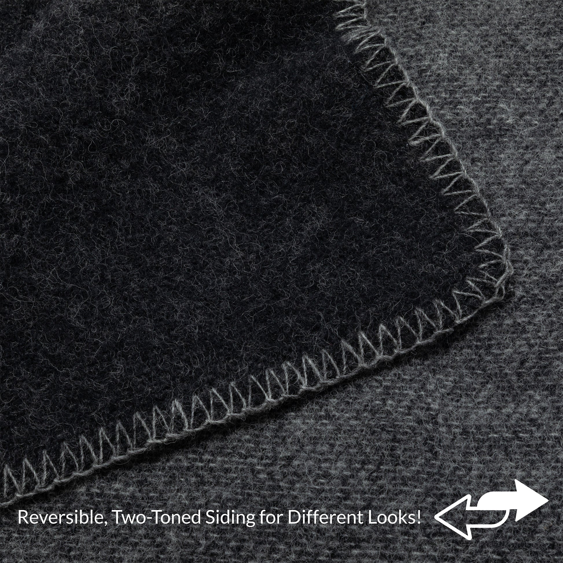 Close-up of a dark charcoal gray textured material with a lighter gray stitched border, showing a reversible two-toned side feature with text overlay at the bottom.