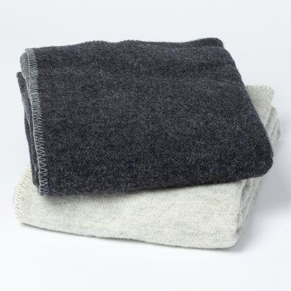 Two folded textured blankets, one dark charcoal gray and one light heather gray, stacked on a white background.
