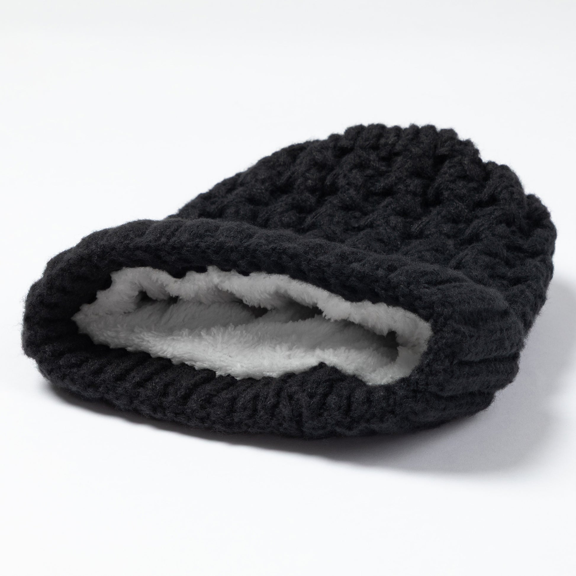 A black textured knit beanie hat with a soft white fleece lining, shown on a clean white background.