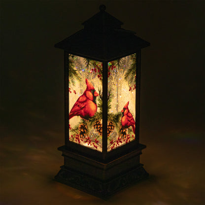 Decorative lantern with red cardinals and Christmas elements on a dark background