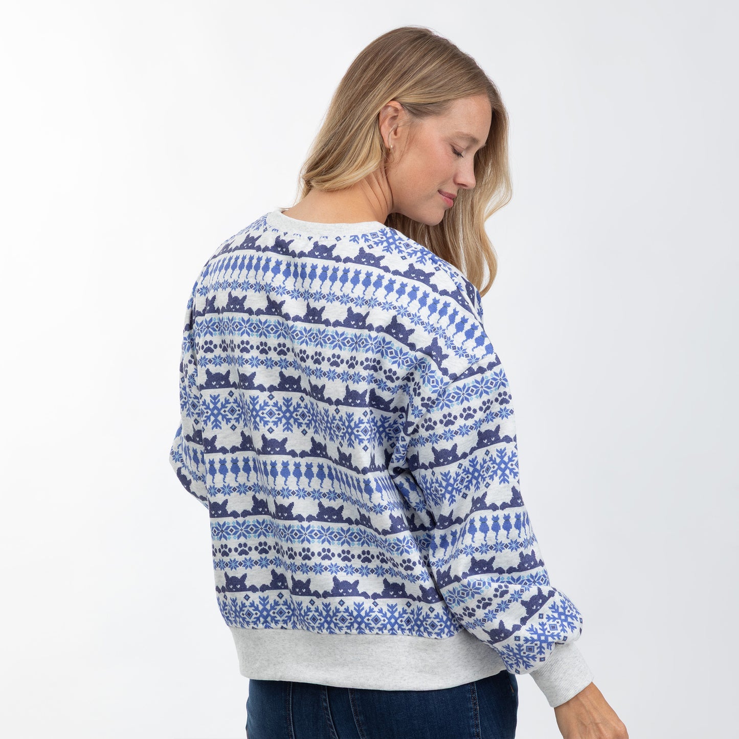 A woman wearing a blue and white patterned crewneck sweater, shown from the back and side against a plain white background.