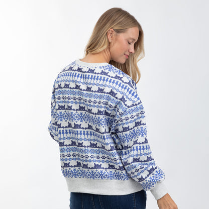 A woman wearing a blue and white patterned crewneck sweater, shown from the back and side against a plain white background.