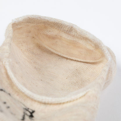 Close-up of a beige no show sock with silicone heel on a white background