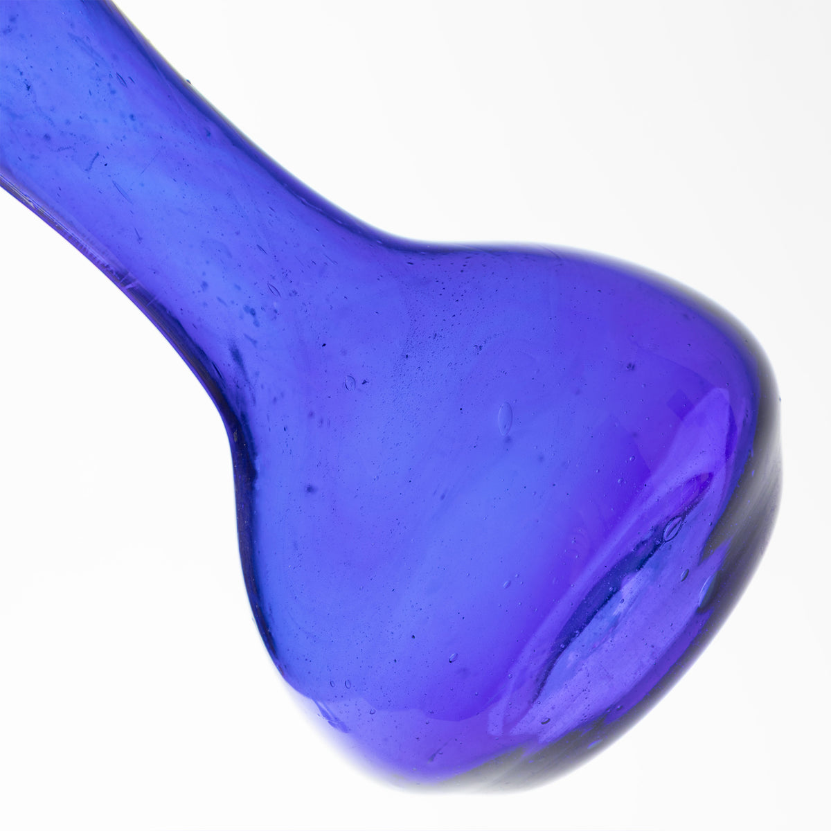 A close-up of a translucent cobalt blue glass vase, on a solid white background.