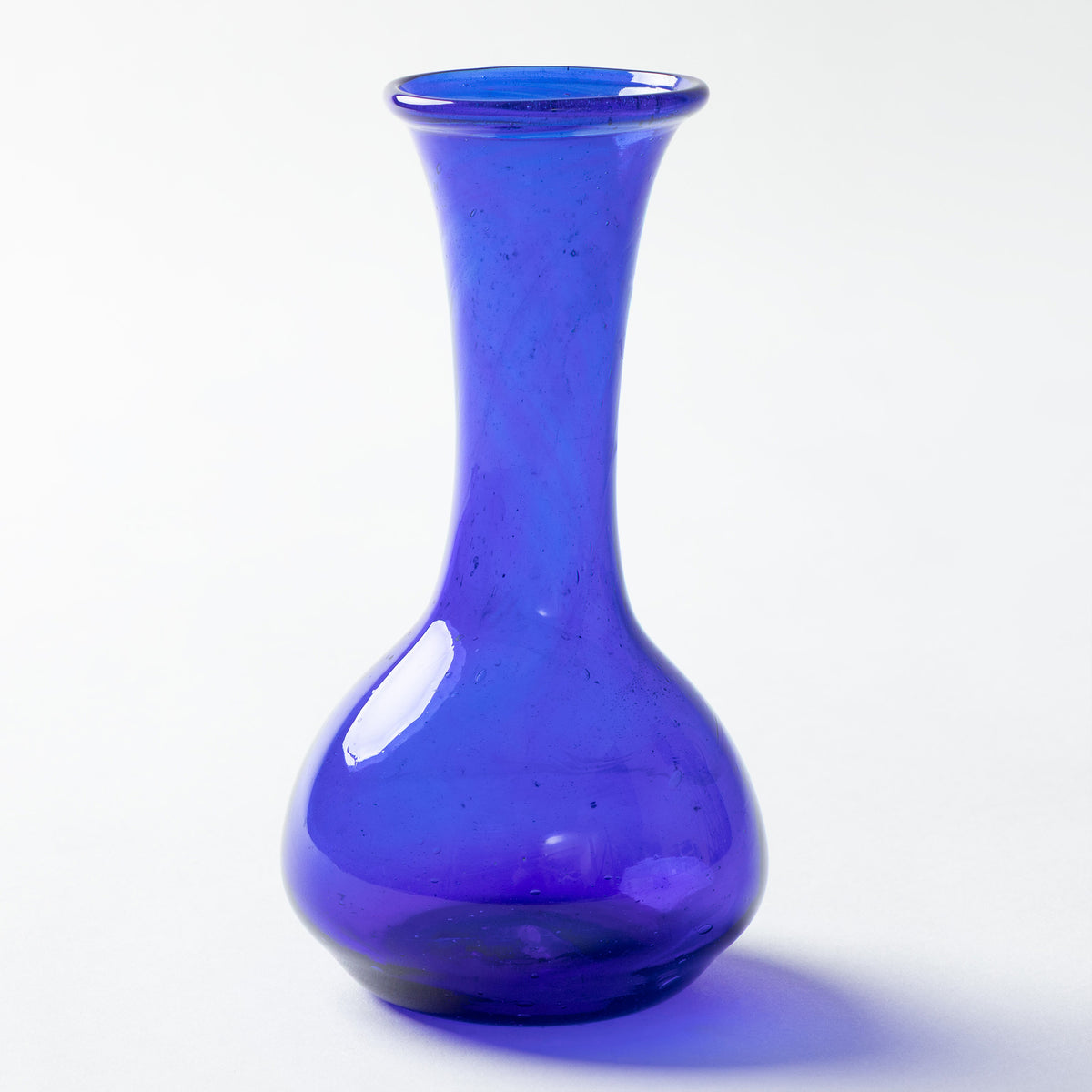 A cobalt blue glass vase with a bulbous base and a narrow neck, photographed on a clean white background.