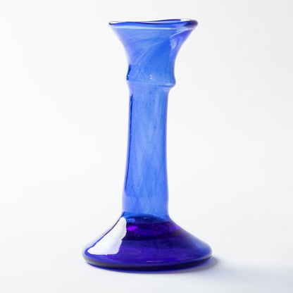 A cobalt blue glass vase with a flared rim and a bulbous base, photographed on a clean white background.