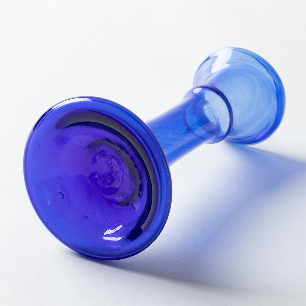 A translucent cobalt blue glass vase photographed on a clean white background.