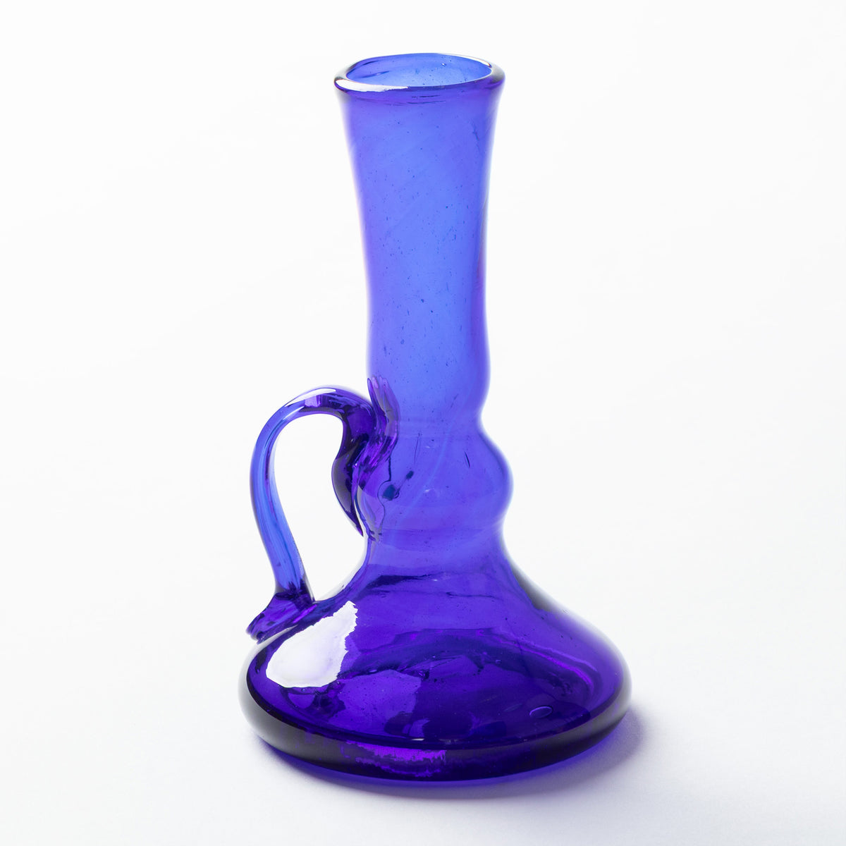 A cobalt blue glass with a curved handle and a flared base, shown on a plain white background.