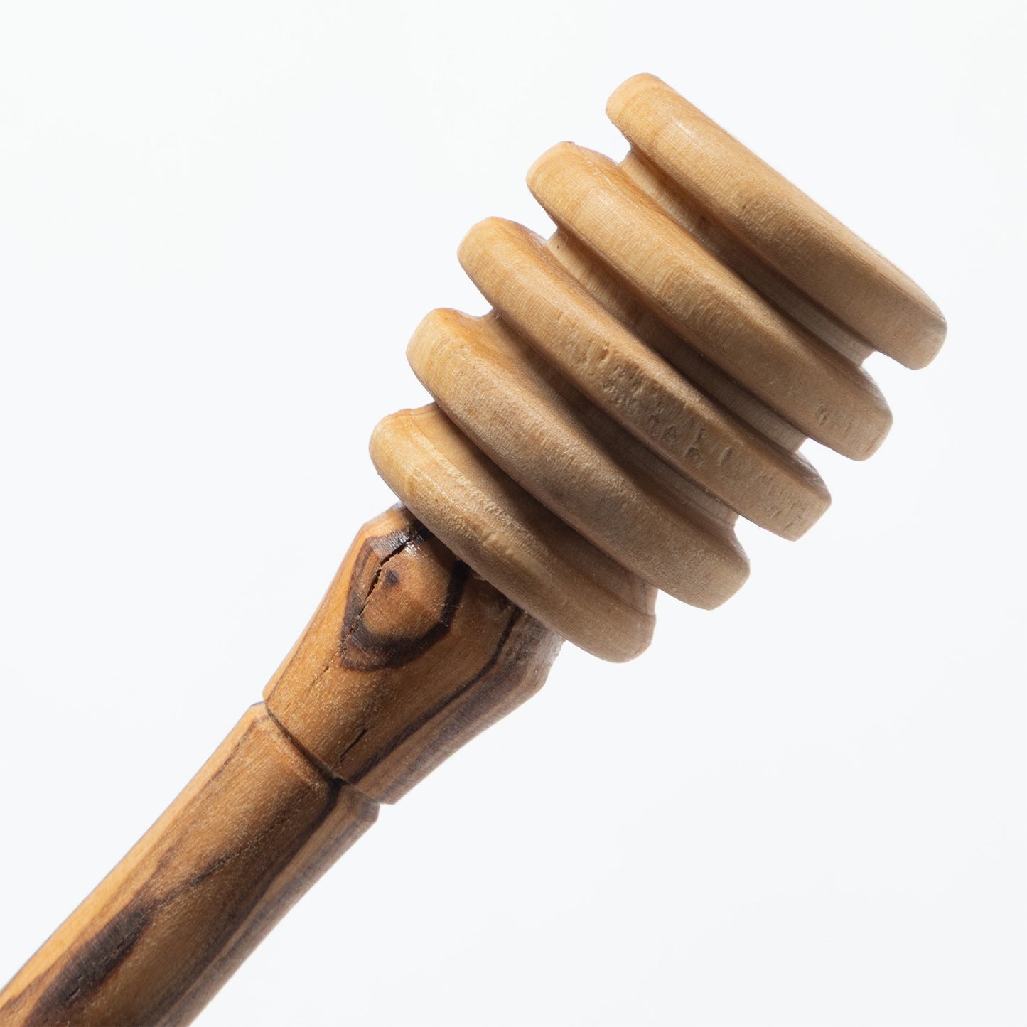 A close-up of a wooden honey dipper with a ribbed spiral head and a smooth handle, shown against a plain white background.