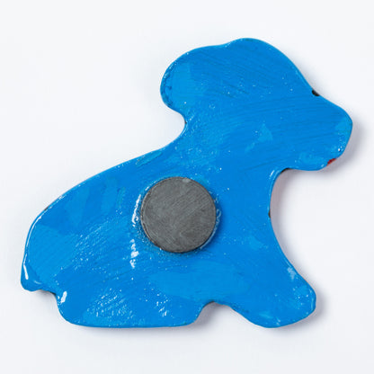 The blue painted back of a ceramic dog magnet.